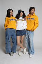 Three people wearing 'Spring Arbor University' hoodies on a gray background